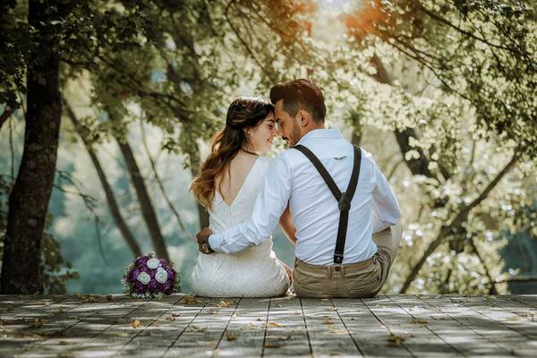 Hochzeitspaar sitzt am Steg und schaut sich an